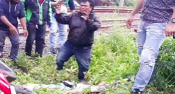 Warga berusaha memberikan pertolongan terhadap korban yang terkapar di samping rel kereta api di Cisauk. FOTO: Tangkapan layar kamera warga.